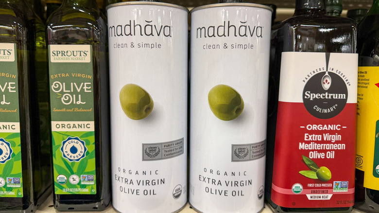 Variety of olive oil containers on grocery store shelf