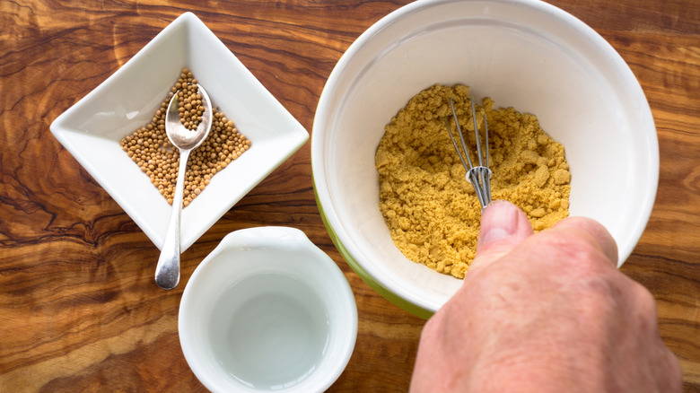 person with bowl of mustard seeds and powder