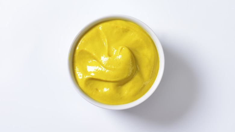 Yellow mustard in small white bowl