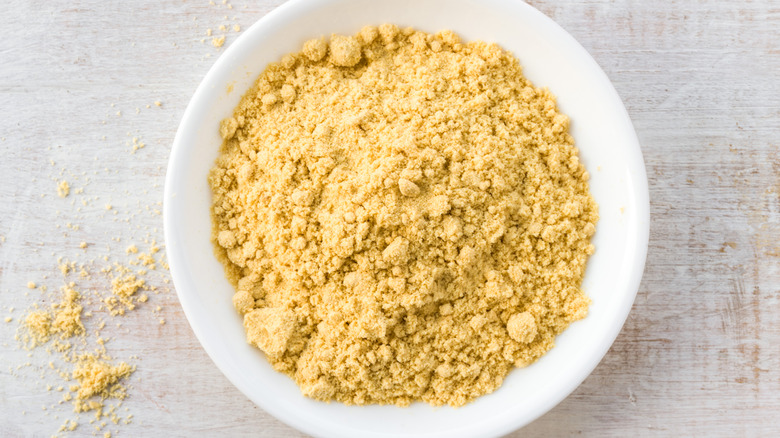 Ground mustard powder in white bowl on countertop