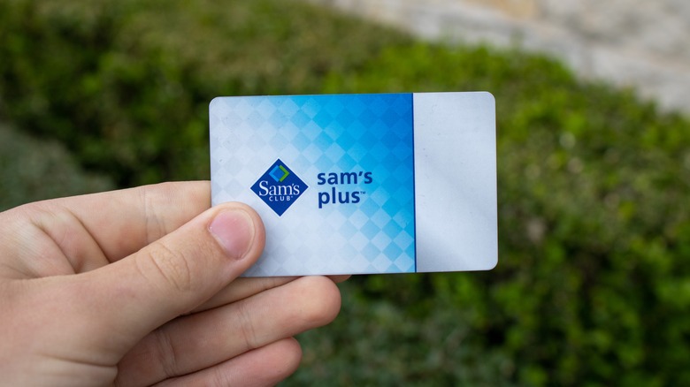 Hand holding Sam's Club Sam's Plus membership card