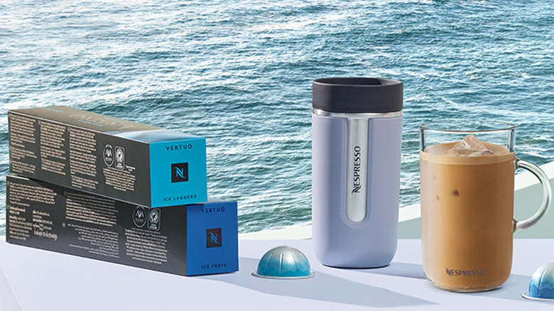 Nespresso Ice Leggero plus cup plus glass mug of iced coffee against a sea background