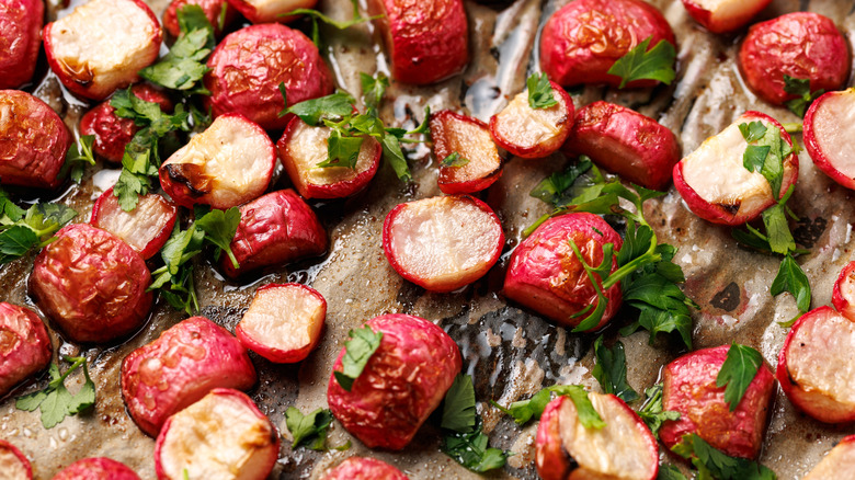 plate of roasted radishes on parchment paper with herb garnish