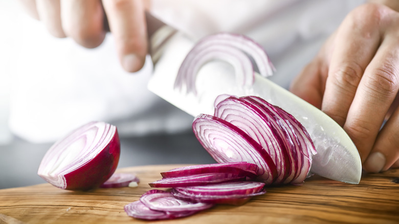 Hand cutting red onion 