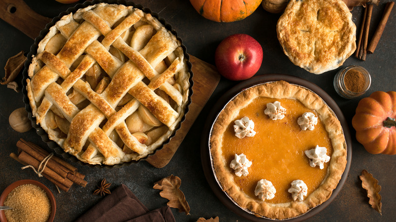 apple pie and pumpkin pie surrounded by ingredients