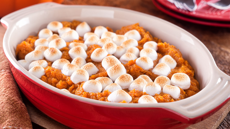 sweet potato casserole with marshmallow topping in ared baking dish