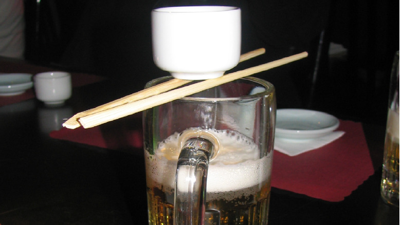 sake shot placed over beer