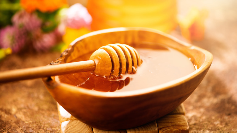 wooden bowl liquid honey dipper