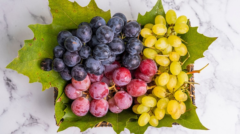 Purple, red, and green grapes in basket