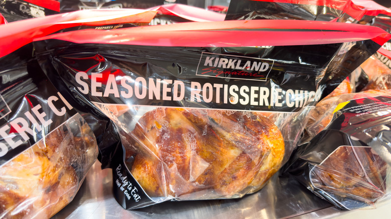 black Kirkland Signature season rotisserie chicken bags with chickens inside sitting on hot shelf