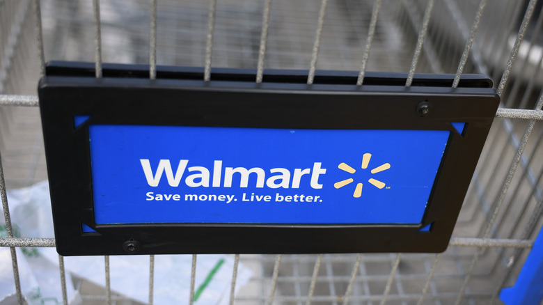 A sign on a shopping cart reading "Walmart Save money. Live better."