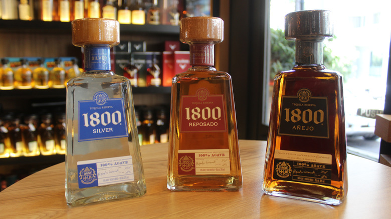 Three bottles of 1800 silver, reposado, and anejo tequila on a table
