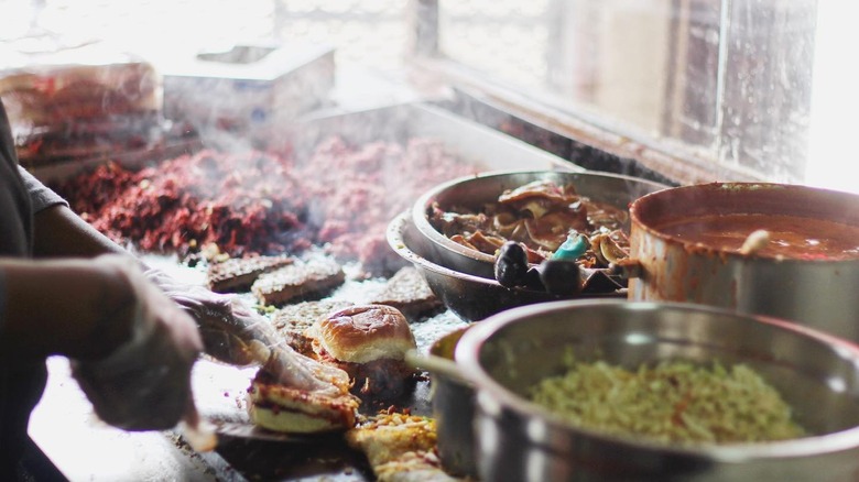 Cook making pig sandwiches at Big Apple Inn