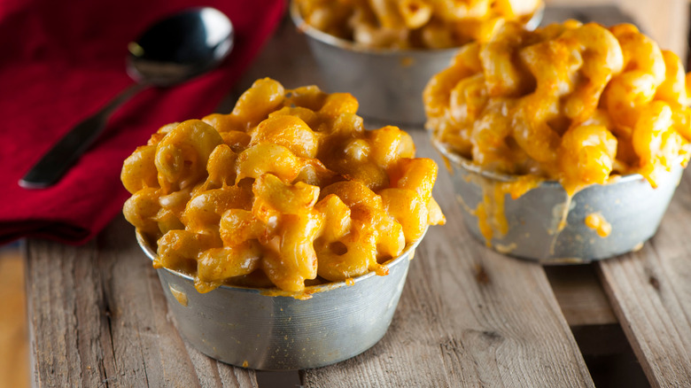 Close-up of gooey mac and cheese bowls on wooden picnic table