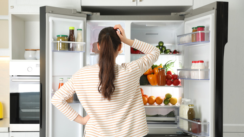 Woman inspects refrigerator