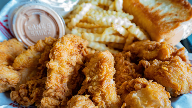 A closeup of a Raising Cane's combo meal with chicken and fries