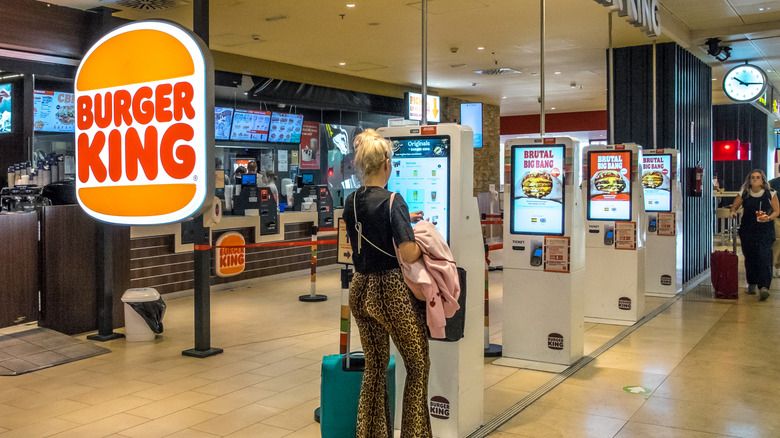 Woman at Burger King order kiosk in airport