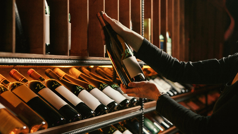 Person picking out a bottle of alcohol