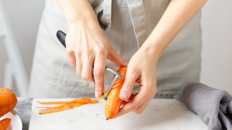 A woman using a vegetable peeler