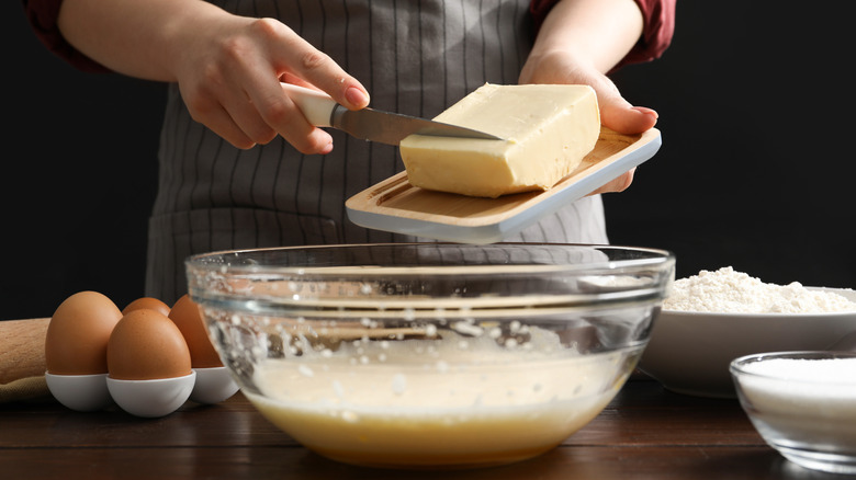 A person bakes with butter