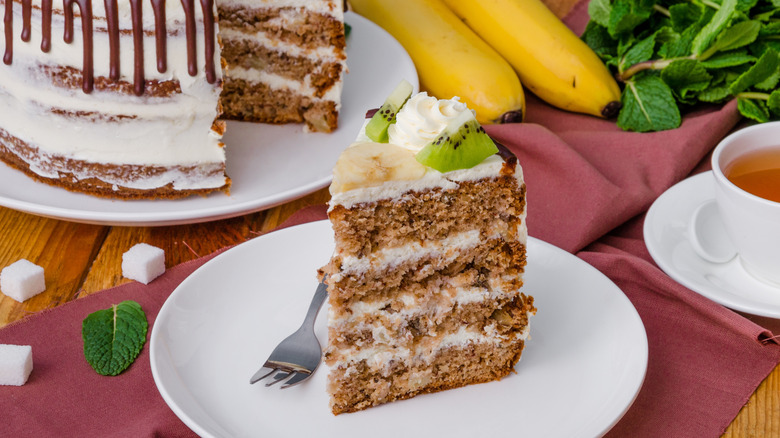 Hummingbird cake slice with bananas, mint, tea, sugar in background
