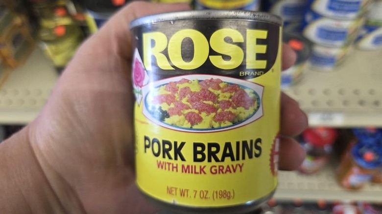 Someone holding a can of Rose Brand canned pork brains