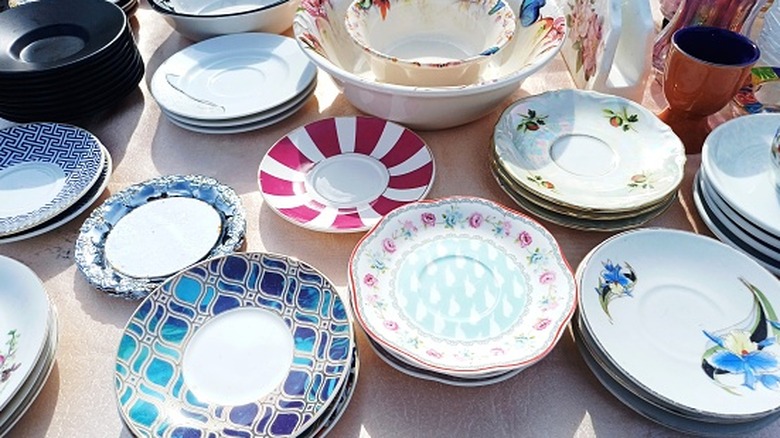 Stacks of various vintage dishes on a table.