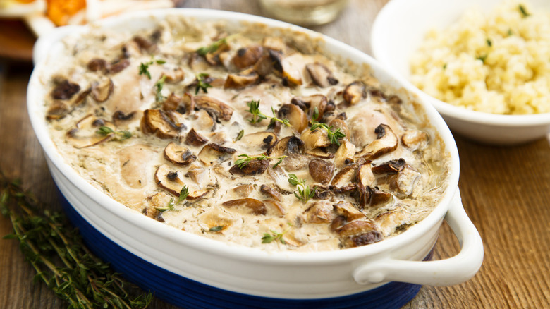 A dish of baked chicken covered in mushrooms.