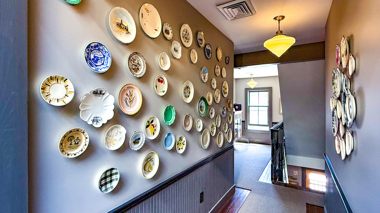 Decorative, colorful vintage plates hanging on the walls of a hallway in a home