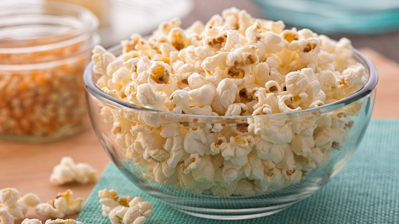 Bowl of popcorn and scattered pieces on table