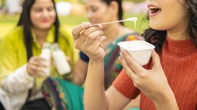 person eating pudding with friends in park