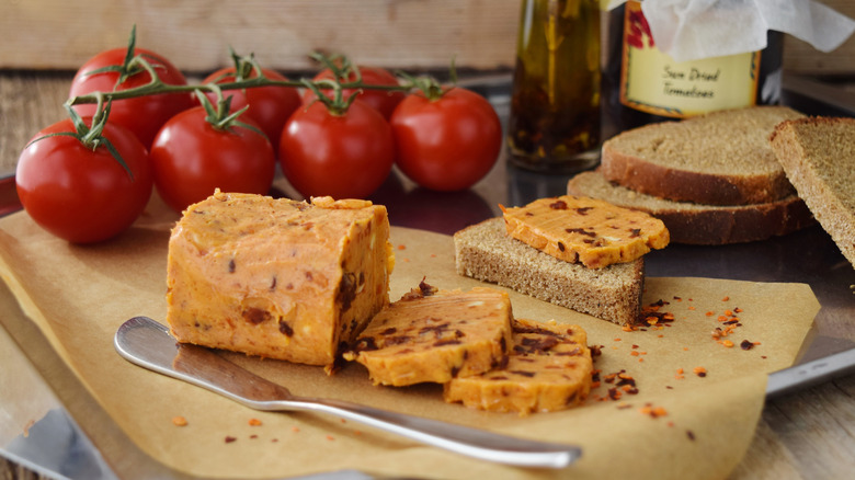 Tomato butter on paper with bread and knife