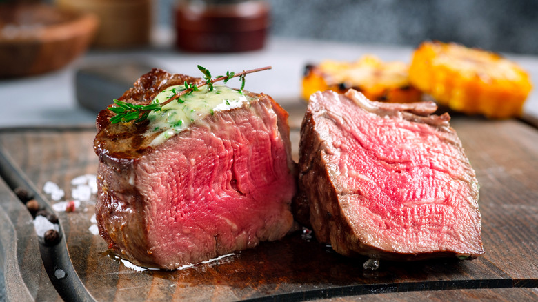 Rare filet mignon steak cut in half served with butter
