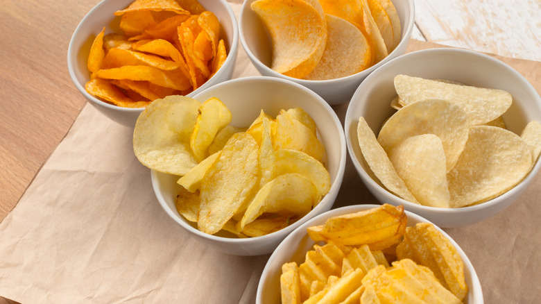 Different shapes and flavors of potato chips in bowls