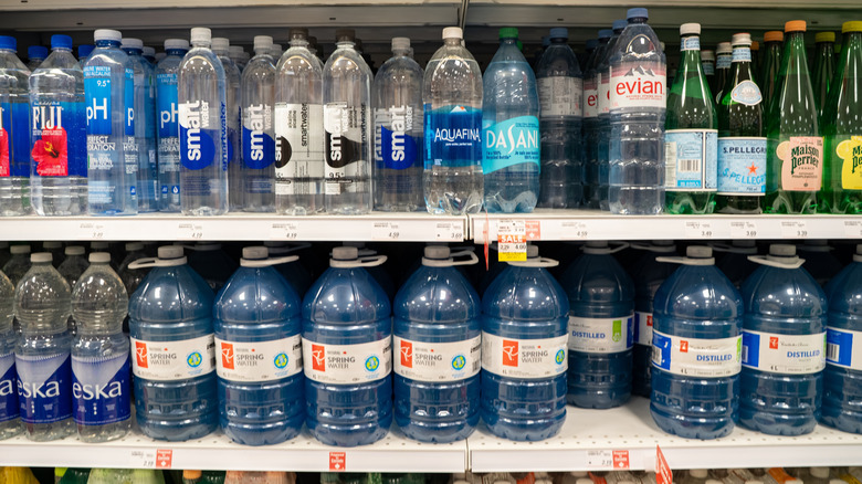 Assorted water bottles on shelves.