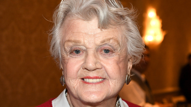 Angela Lansbury smiles with silver earrings