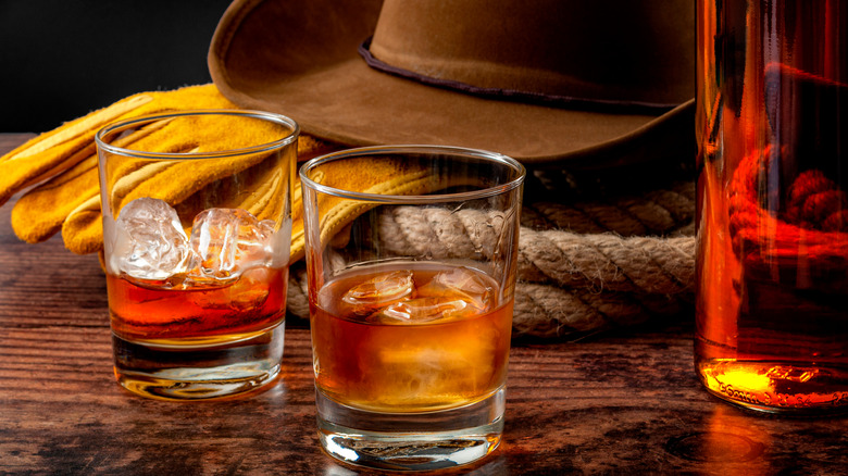 Whiskey glasses in front of a cowboy hat