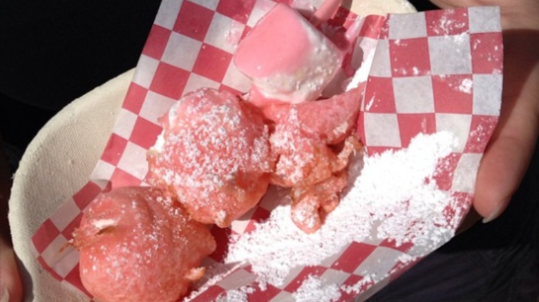 Pieces of deep-fried bubble gum on tray with powdered sugar.