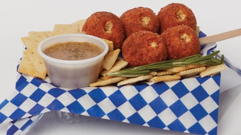 Balls of deep-fried chicken soup on stick with crackers, and bowl of broth.
