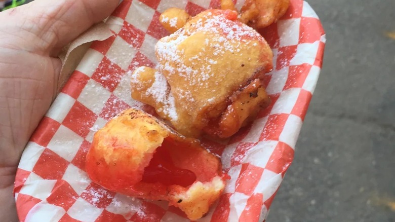 Pieces of deep-fried red Jell-O on tray.