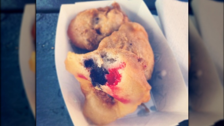 Pieces of fried dough with jelly beans in tray.
