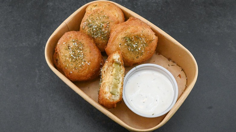 Four deep-fried Oreos with pickles and dipping sauce.