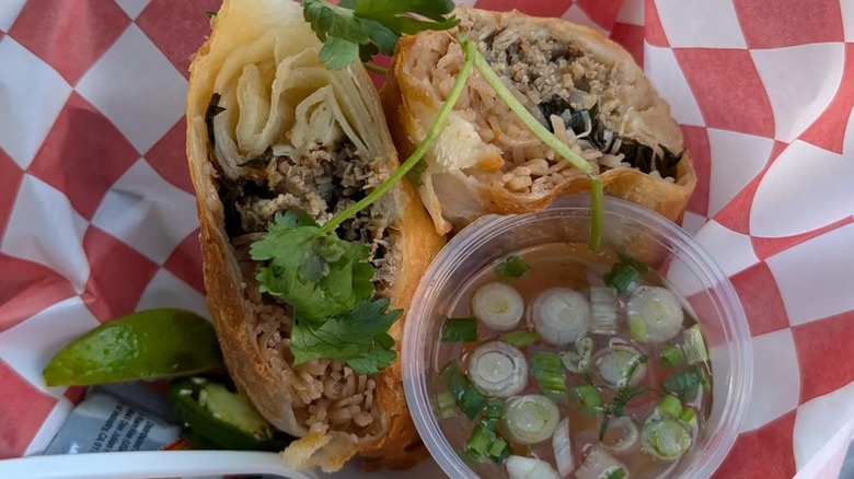 Two halves of deep-fried pho, with broth in cup.