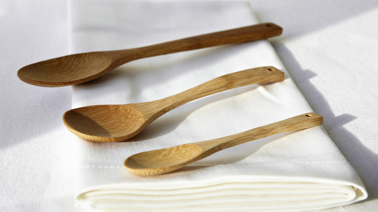 Three wooden spoons on folded napkin