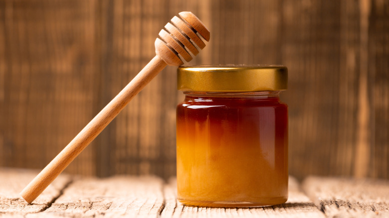 Honey dipper and jar of honey