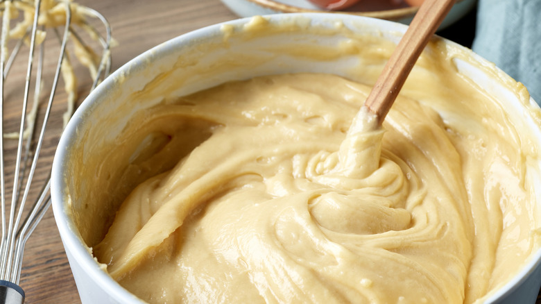 making custard in a bowl with wooden spoon