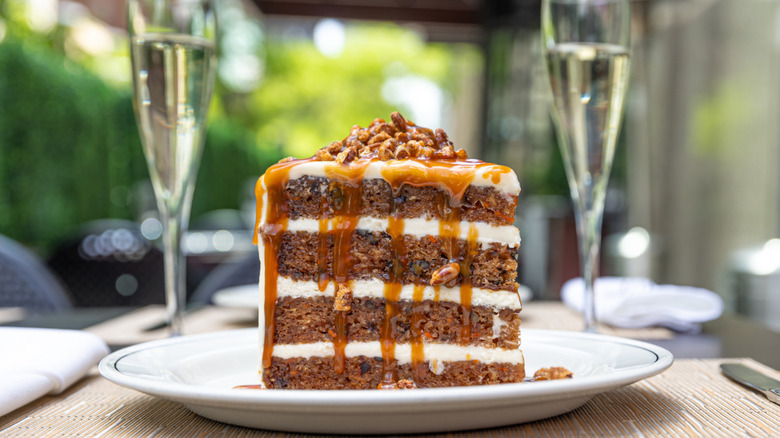 Truluck's carrot cake on white plate with wine in background