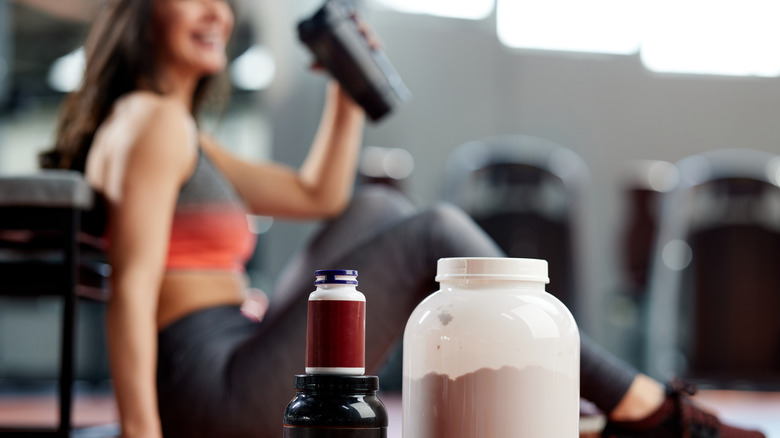 person in gym drinking protein shake