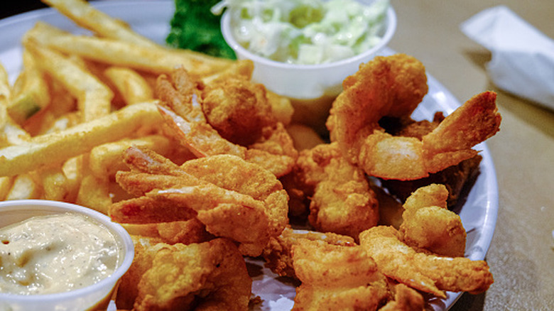 A restaurant fried shrimp dinner with fries and coleslaw