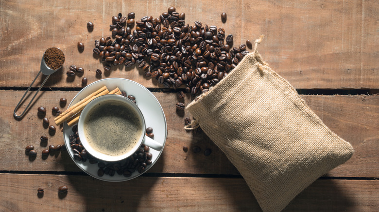 Cup of coffee next to coffee beans